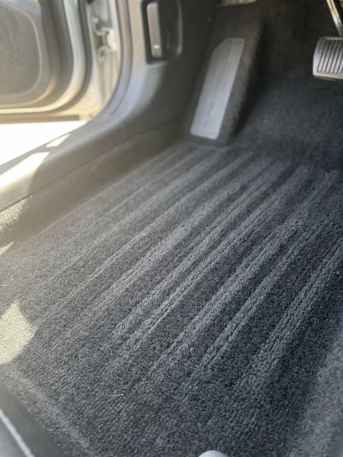 Close view of freshly vacuumed carpet in a vehicle footwell