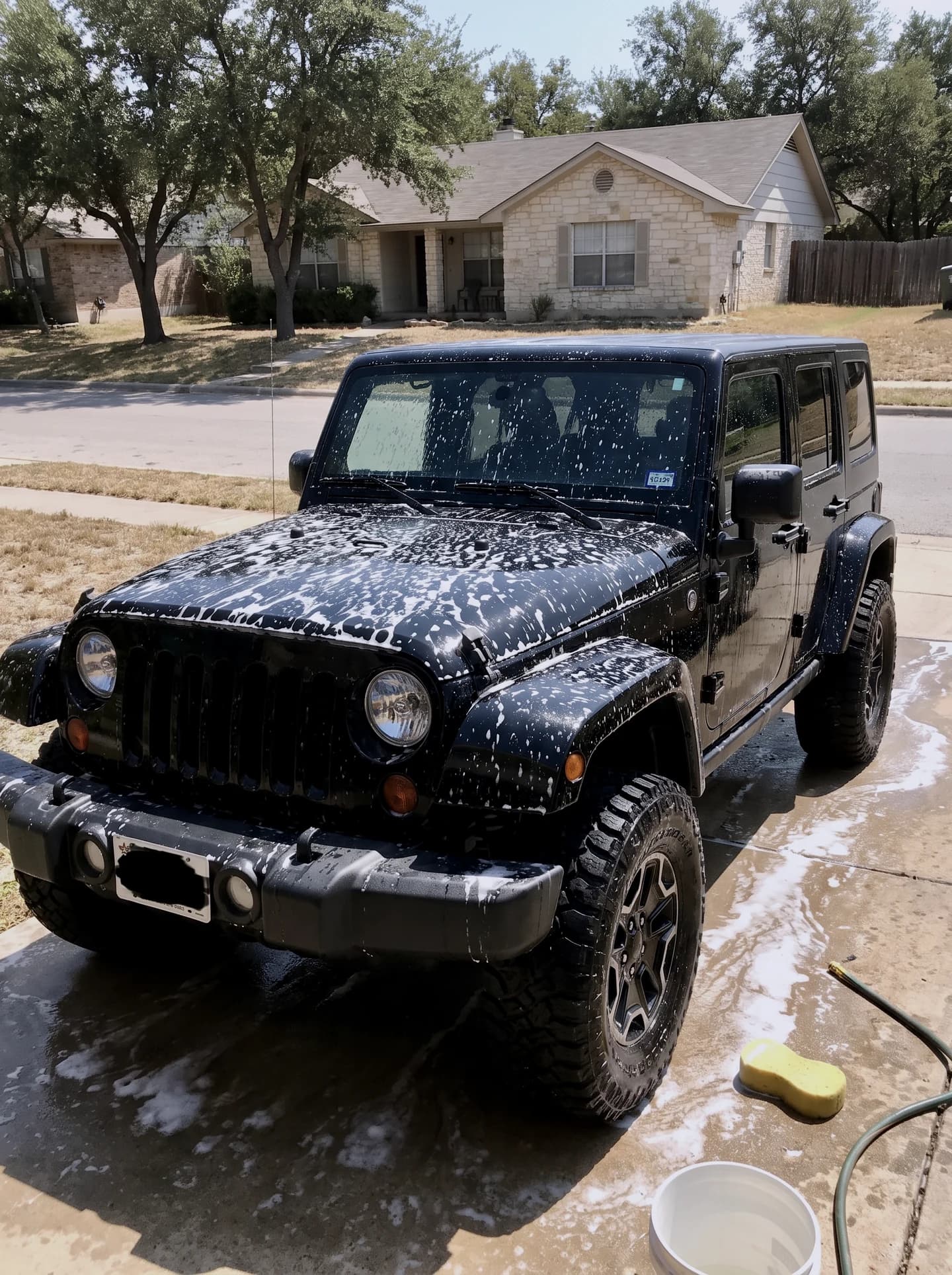 Jeep Wrangler being washed in a driveway
