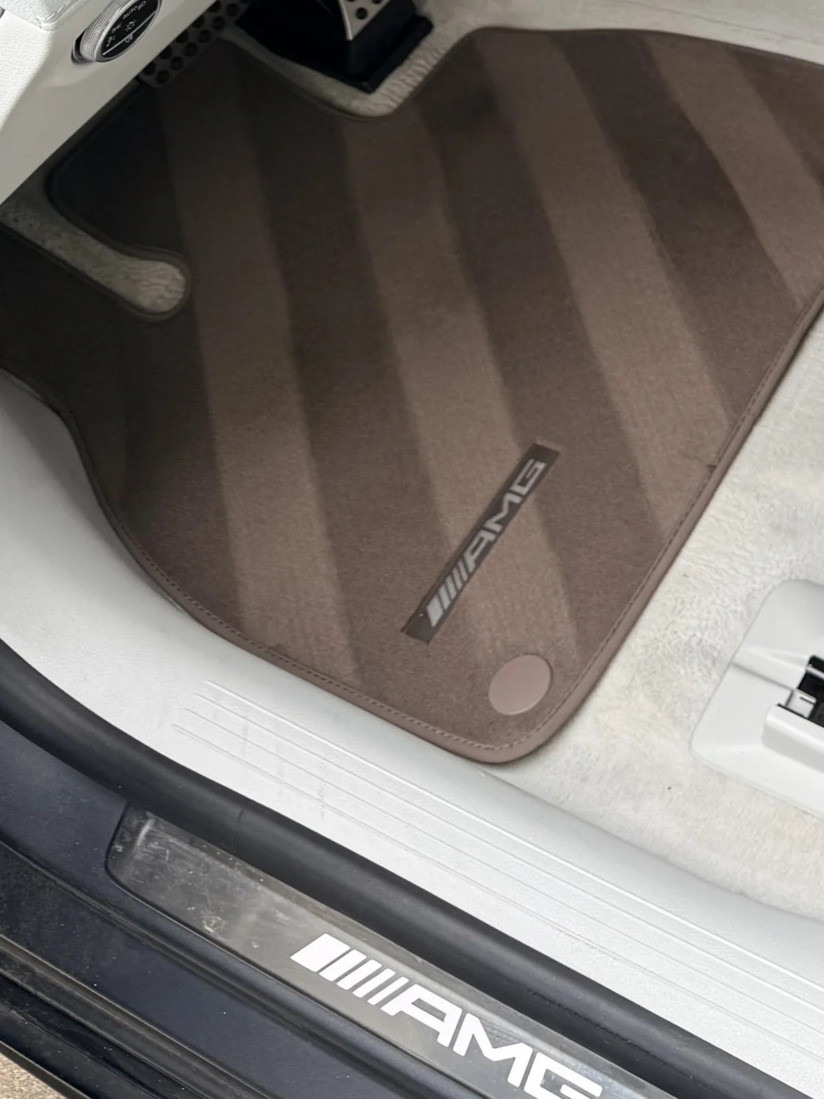 Extracted floor mat and cleaned door sill in a Mercedes AMG